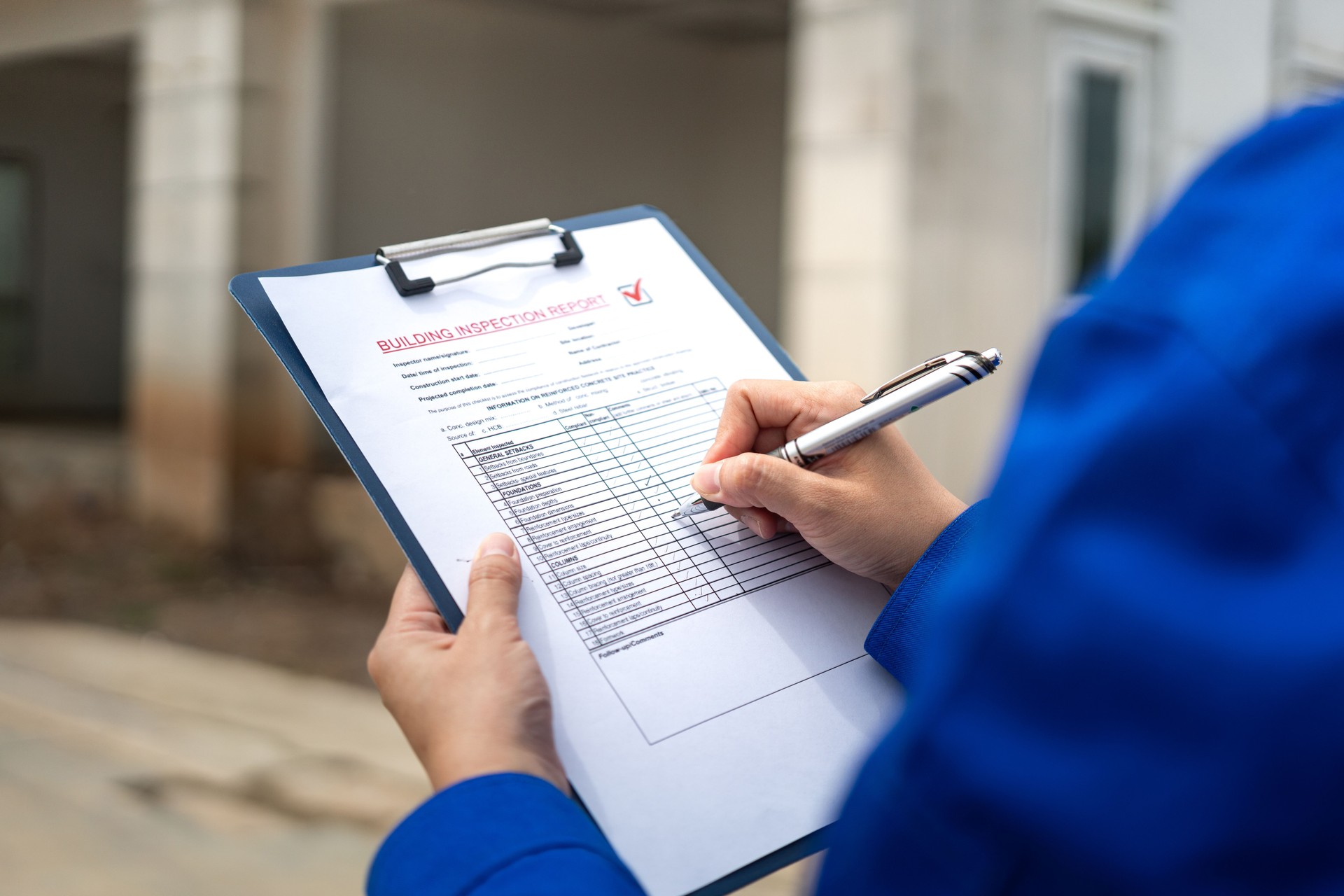 A construction foreman is checking on building quality checklist report.